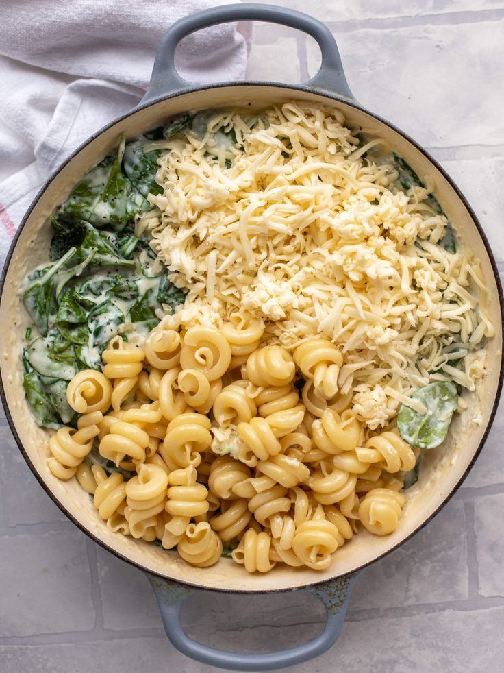 a pan filled with macaroni and cheese on top of a white table cloth