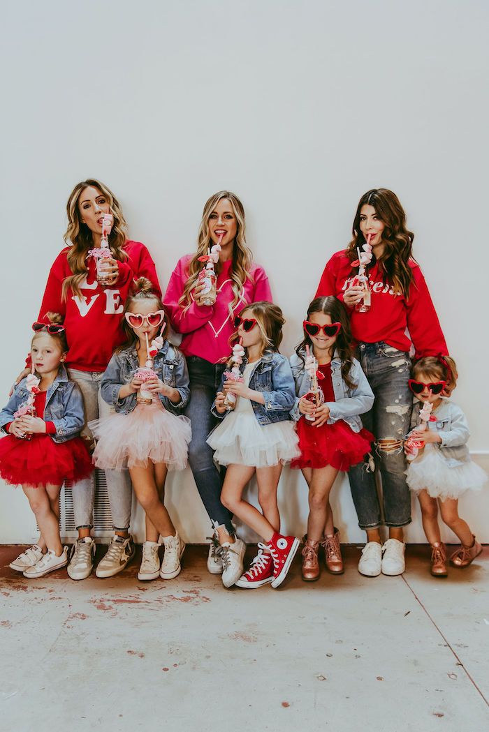 a group of women in red shirts and tutu skirts posing for a photo together