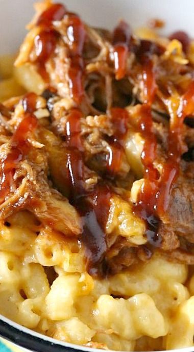 a white bowl filled with macaroni and cheese covered in bbq beef sauce