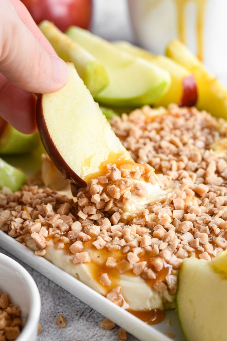 someone is dipping some kind of dessert into an apple and oatmeal casserole