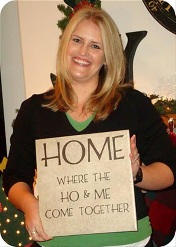 a woman holding a sign that says home where the ho & me come together