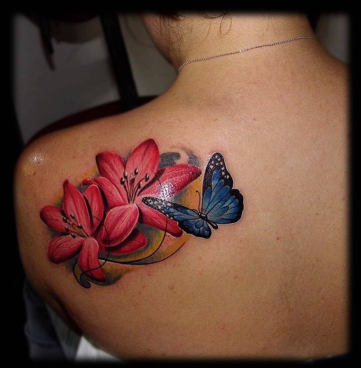 a woman with a butterfly and flowers tattoo on her back