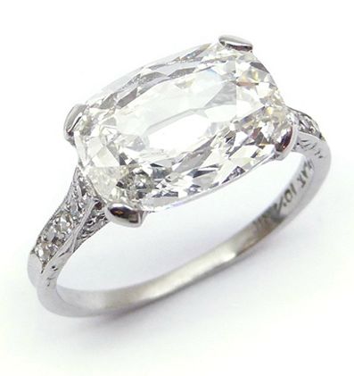 an old cut diamond ring on a white background