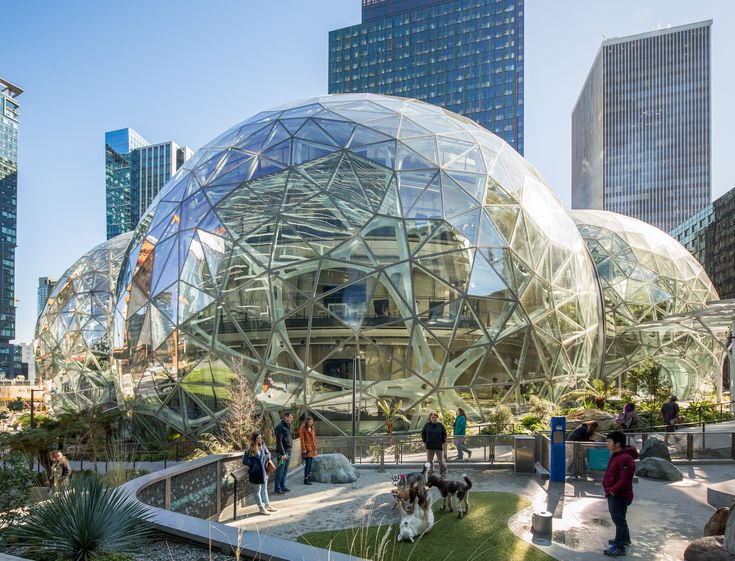 people are walking around in the city with large glass domes