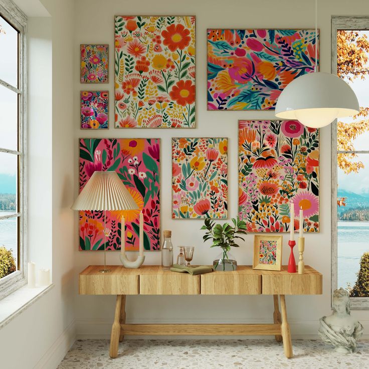 a room with paintings on the wall and a table in front of it next to a window