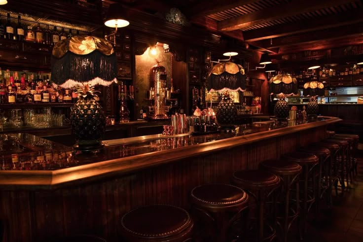 a dimly lit bar with stools in front of it