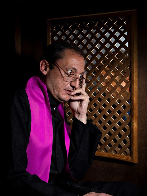 a man sitting in front of a window with his hand on his chin and looking off to the side