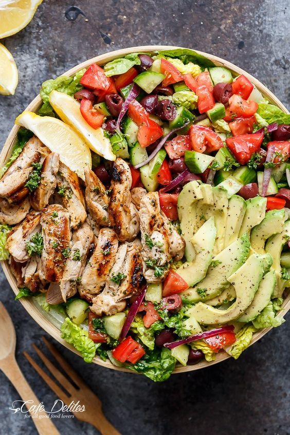 a salad with chicken, lettuce, tomatoes and cucumbers