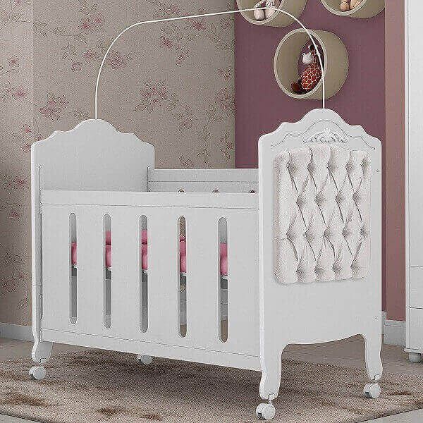 a white baby crib in a pink room