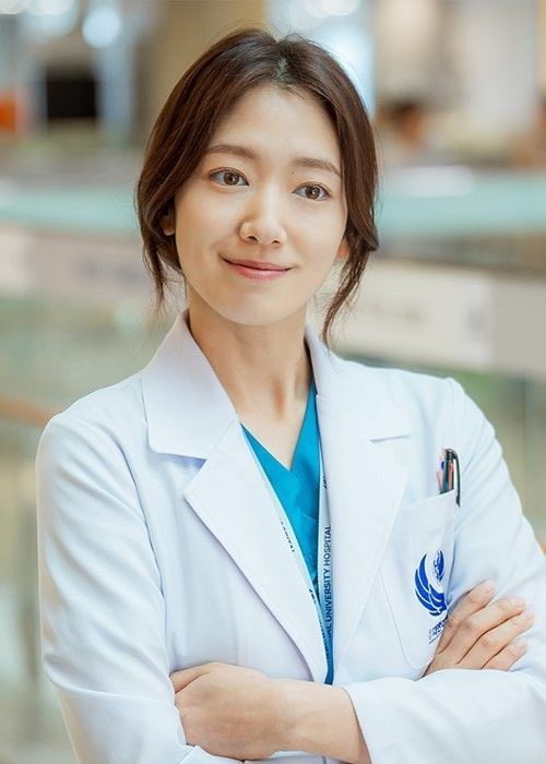 a woman in a white lab coat with her arms crossed