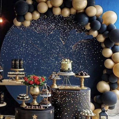 a table topped with cakes and desserts under a star filled sky backdrop at a party