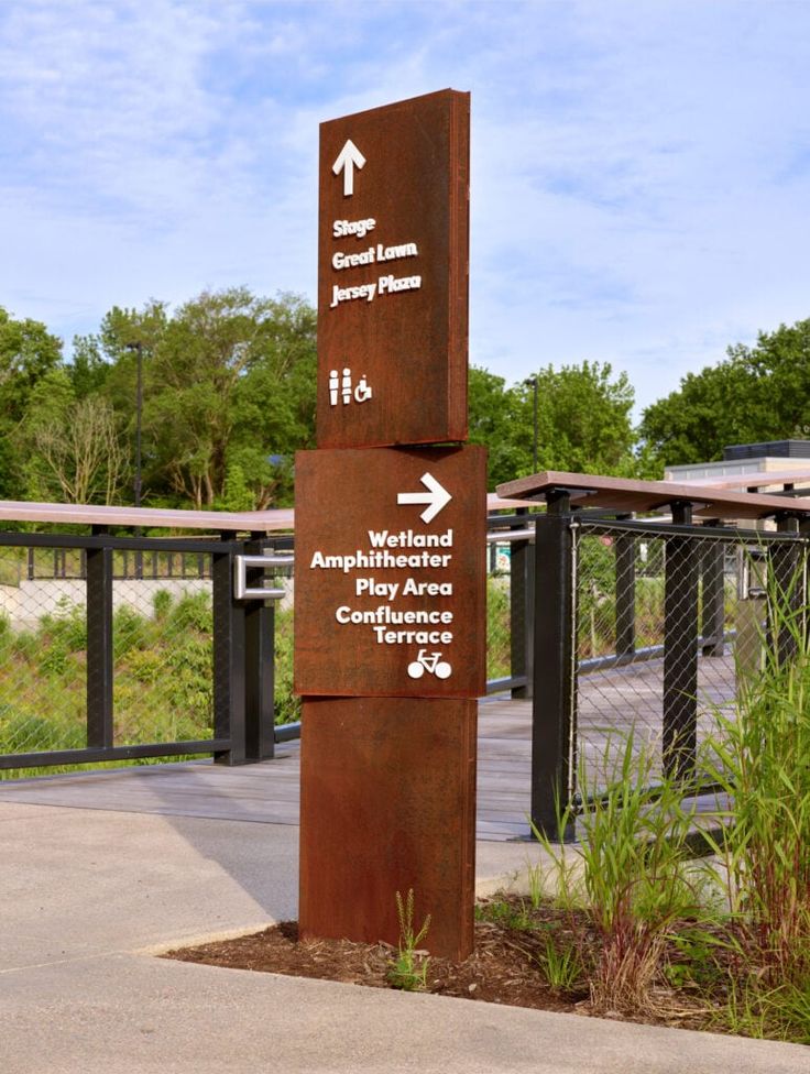 a sign pointing in different directions at the park