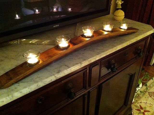 candles are lit in front of a television on top of a cabinet with a wooden handle