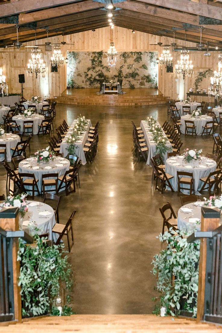 an indoor venue with tables, chairs and chandeliers set up for a formal function