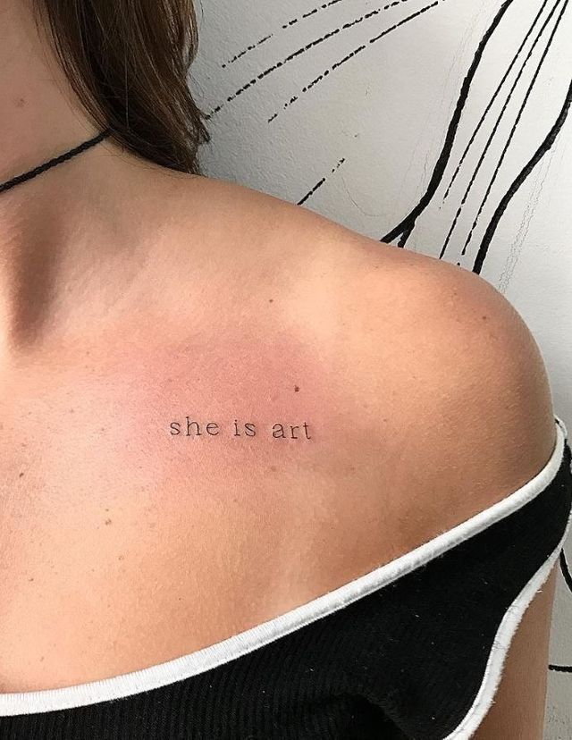 the back of a woman's shoulder with she is art written in cursive font