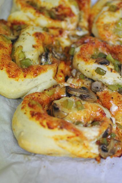 the pizza is topped with mushrooms, green peppers and other toppings on parchment paper