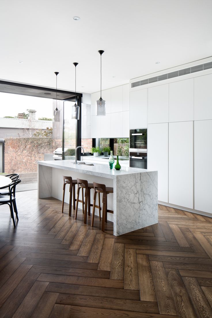 a kitchen with white cabinets and wooden floors