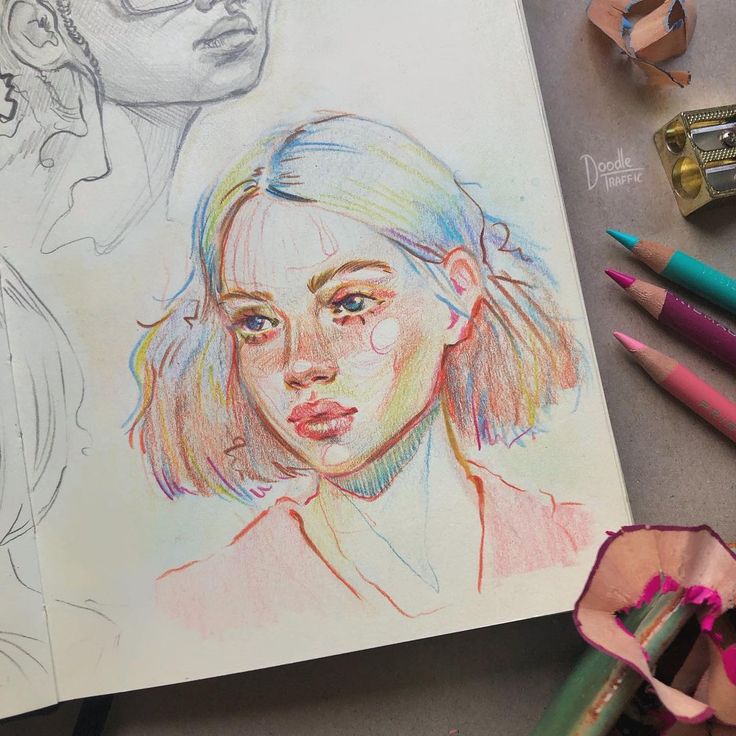 two colored pencils next to a drawing of a woman's face and head