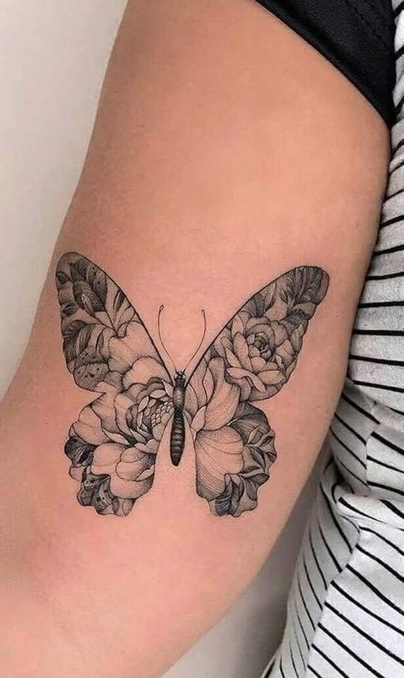 a woman's thigh with a butterfly and flowers tattoo on it