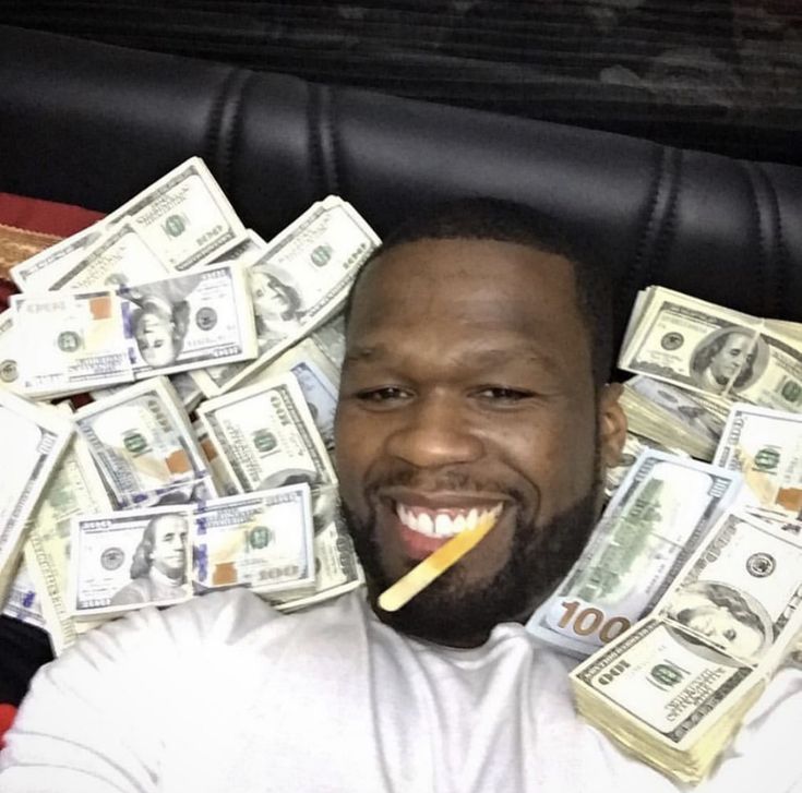 a man sitting in a chair with money on his lap and a pencil sticking out of his mouth