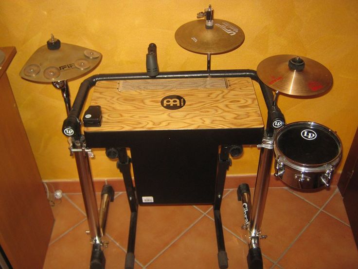 an electronic drum set up on top of a wooden table in a room with yellow walls