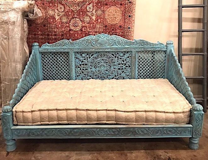 a blue bench sitting next to a red rug