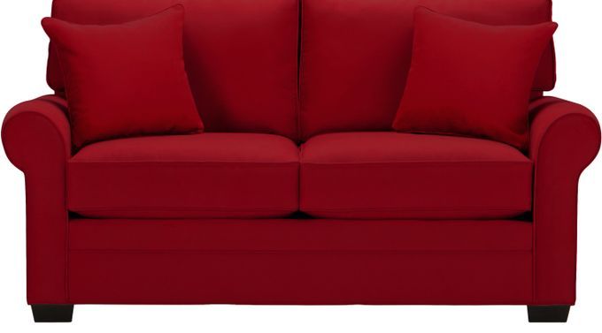 a red couch with two pillows on it