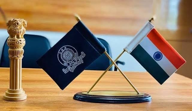 two miniature flags sitting on top of a wooden table