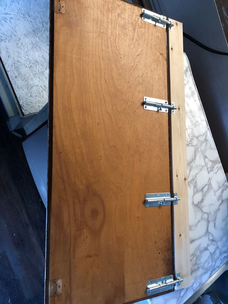 an open wooden box sitting on top of a table next to another box with metal handles