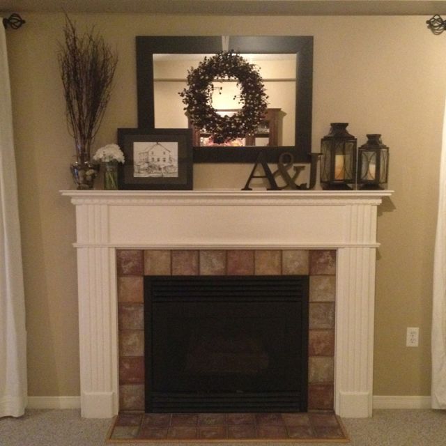 a living room with a fire place and wreath on the mantel over the fireplace