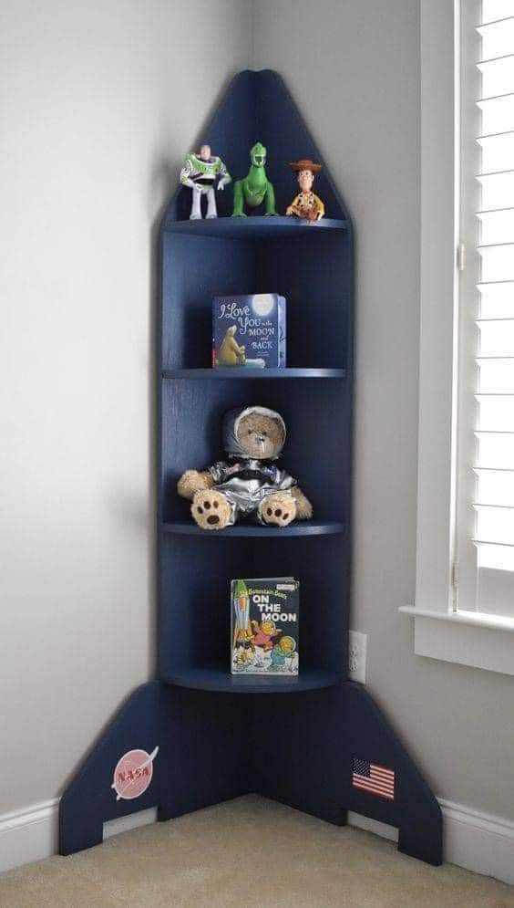 a blue shelf in the corner of a room with toys on it and bookshelves