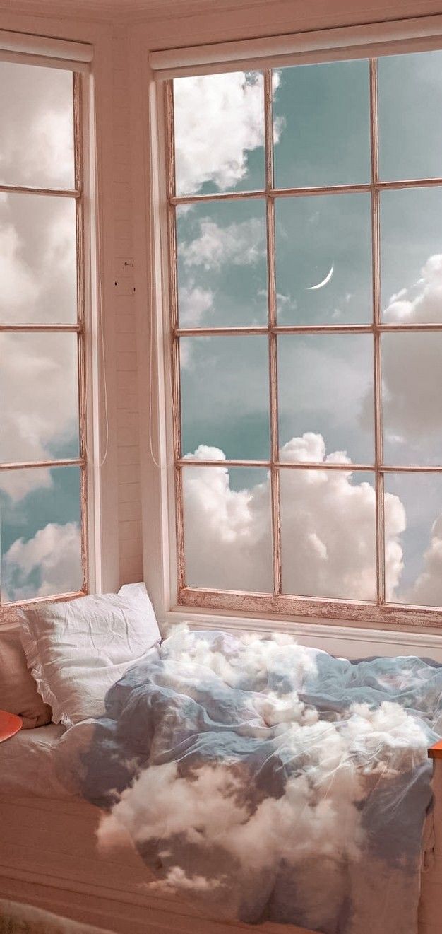 a bed sitting in front of two windows with clouds painted on the walls and floor