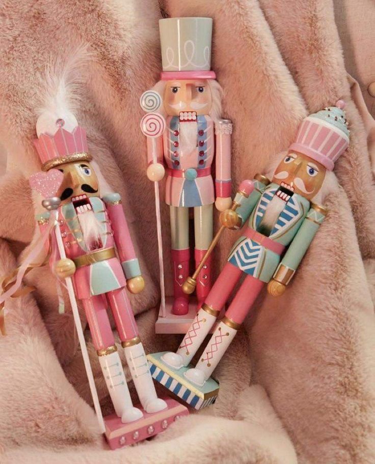 three wooden nutcrackers sitting on top of a blanket