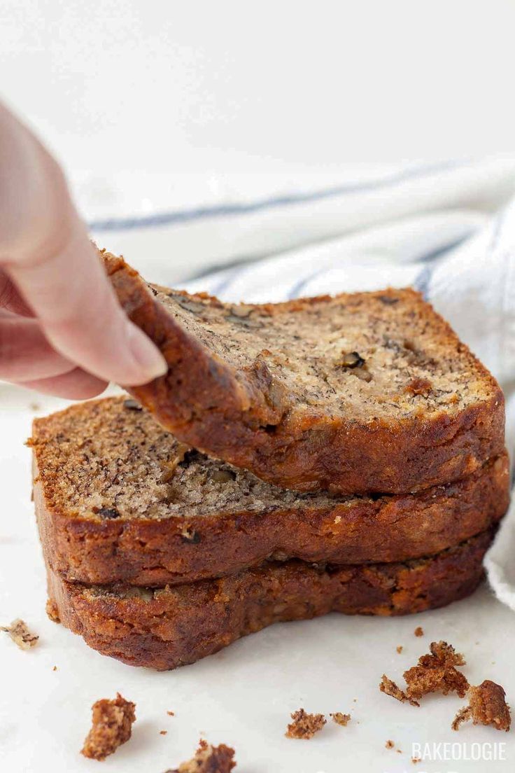 two slices of banana bread on top of each other, being held up by someone's hand