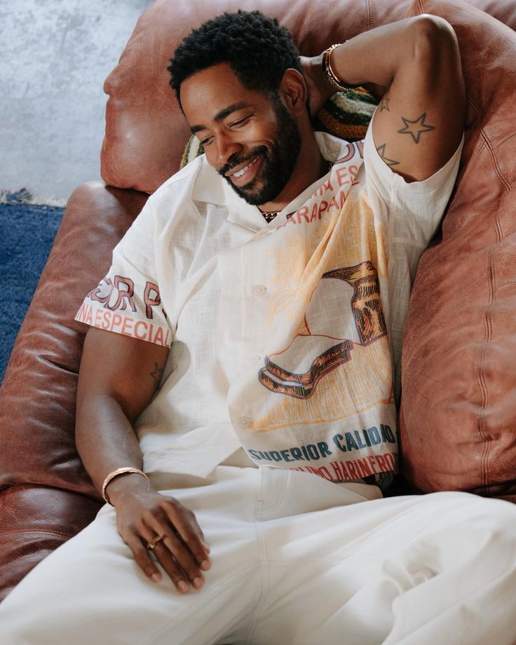 a man laying on top of a brown couch