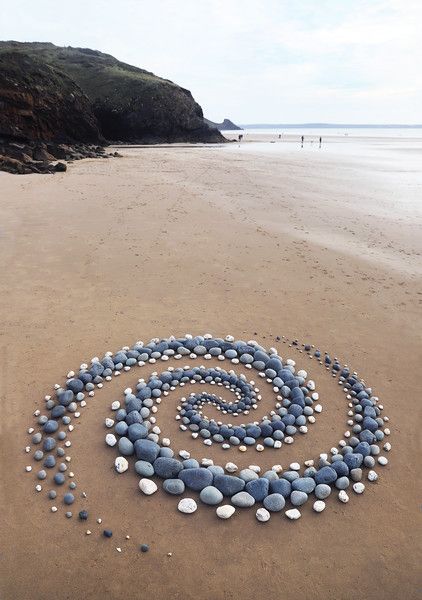 a spiral made out of rocks on the beach