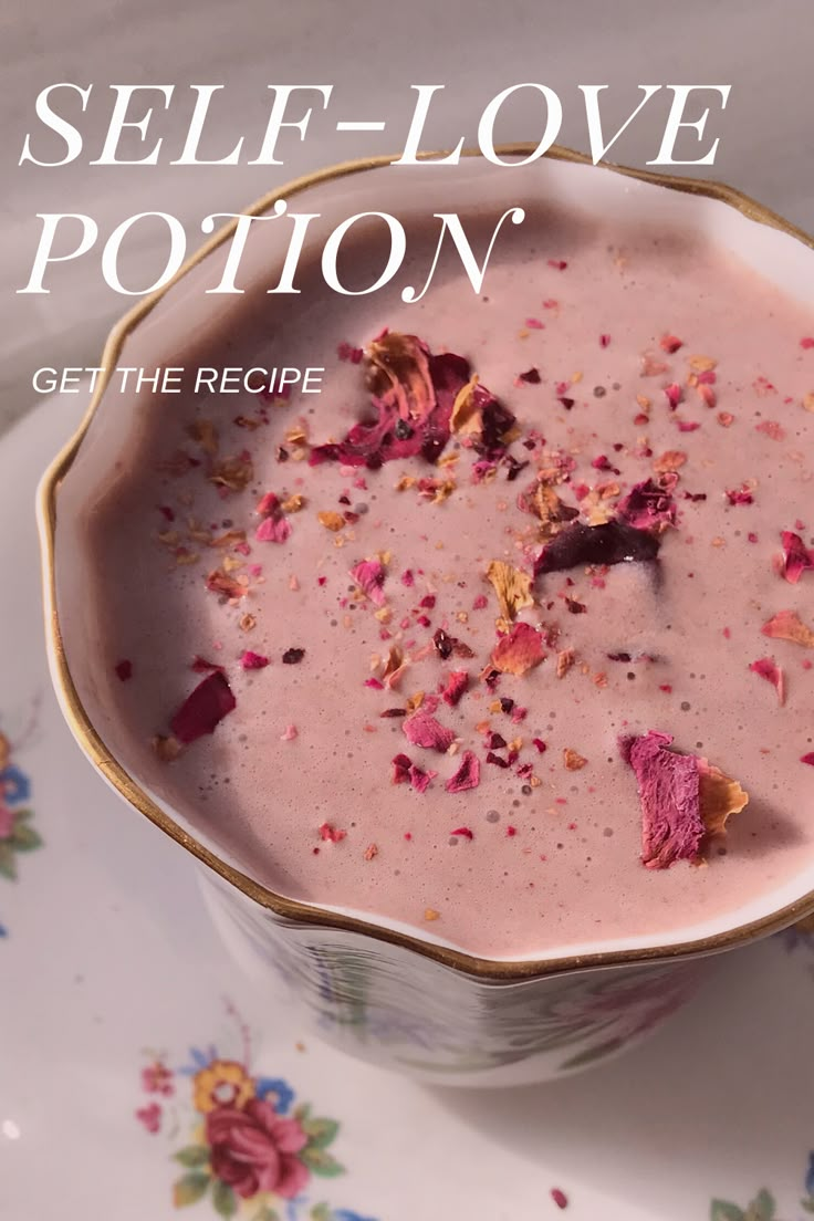 a bowl filled with food on top of a white and pink plate next to a spoon