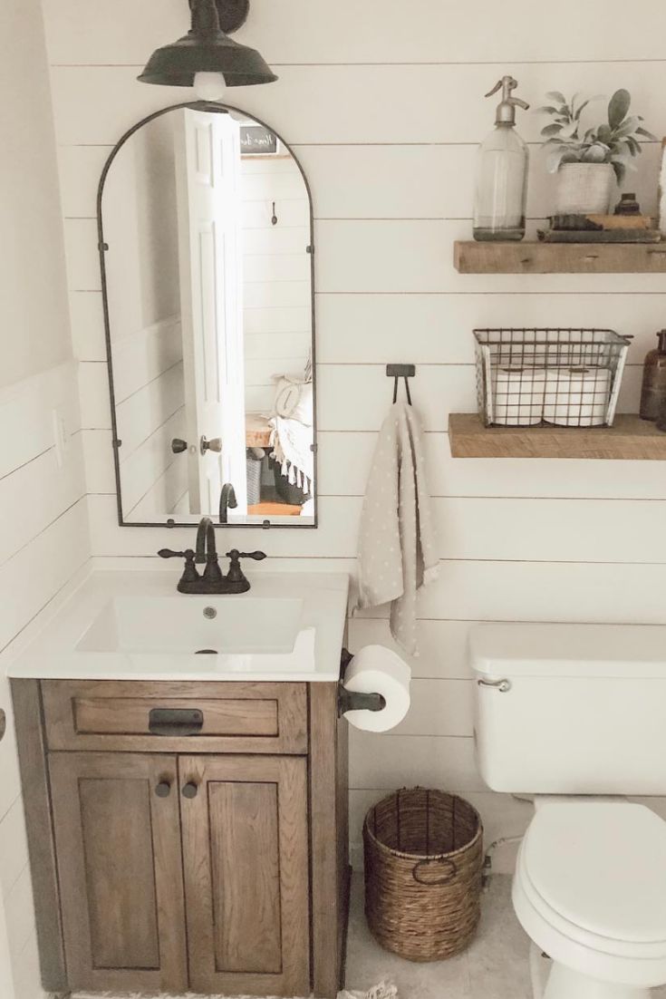 a bathroom with a toilet, sink and mirror in it's centerpieces