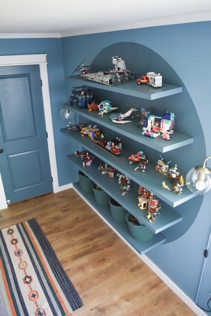 a blue room with shelves filled with toys