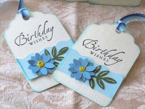 two tags with blue flowers are on a table