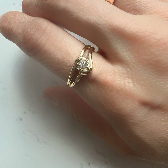 a woman's hand with a gold ring on it and a diamond in the middle