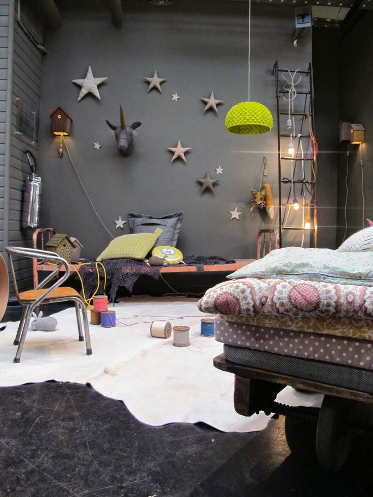 a bed sitting in the middle of a room next to a wall with stars on it