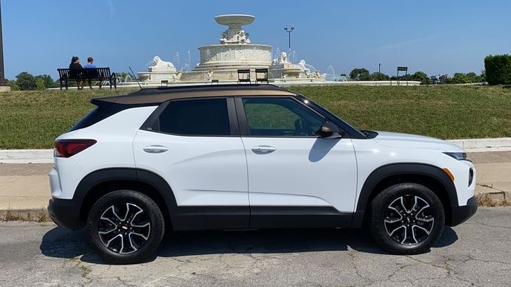 a white suv parked in front of a fountain