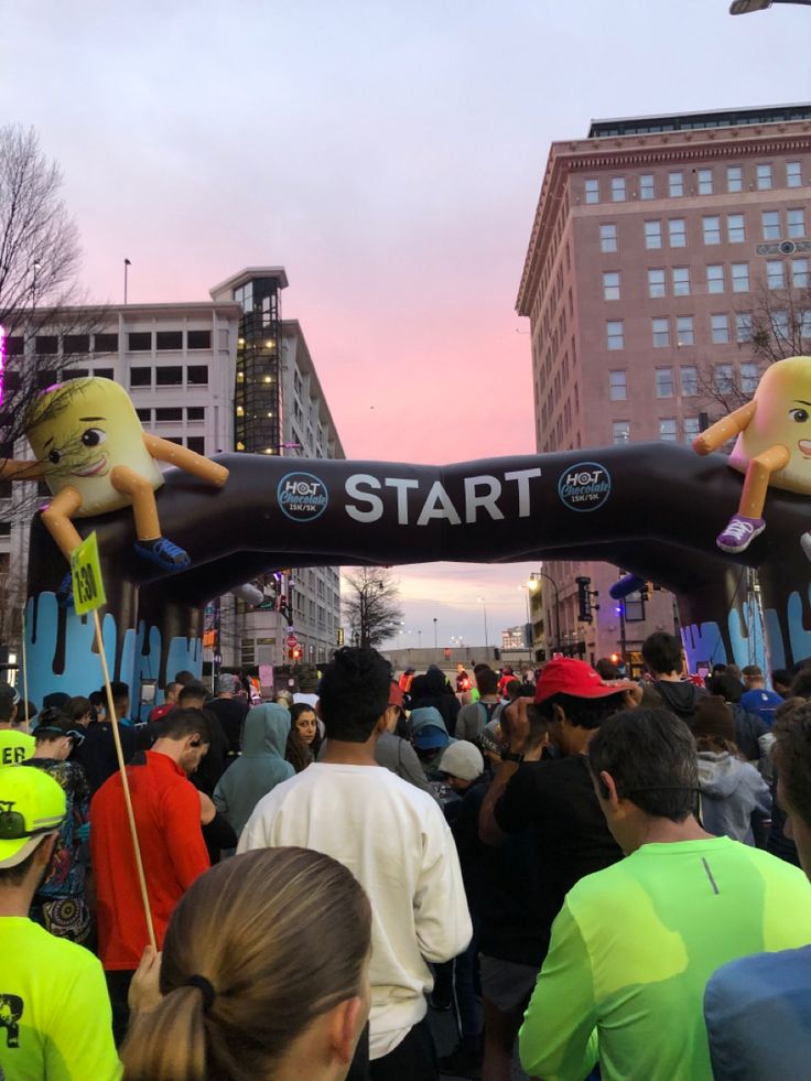 a group of people that are standing in front of a start sign with stuffed animals on it