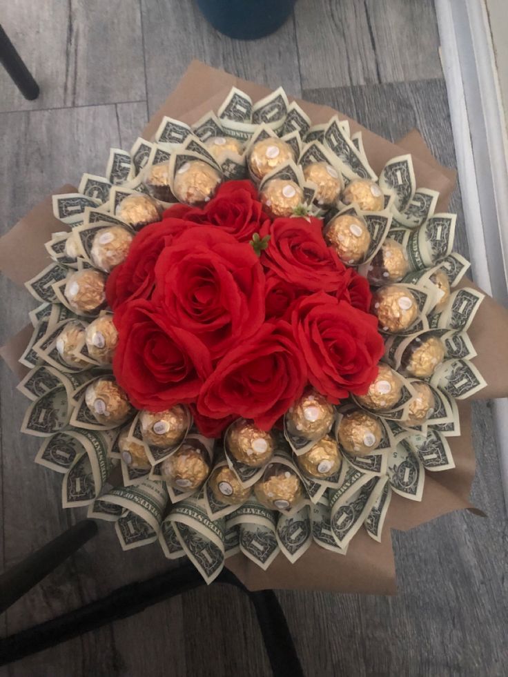 a bouquet of roses and chocolates on top of money