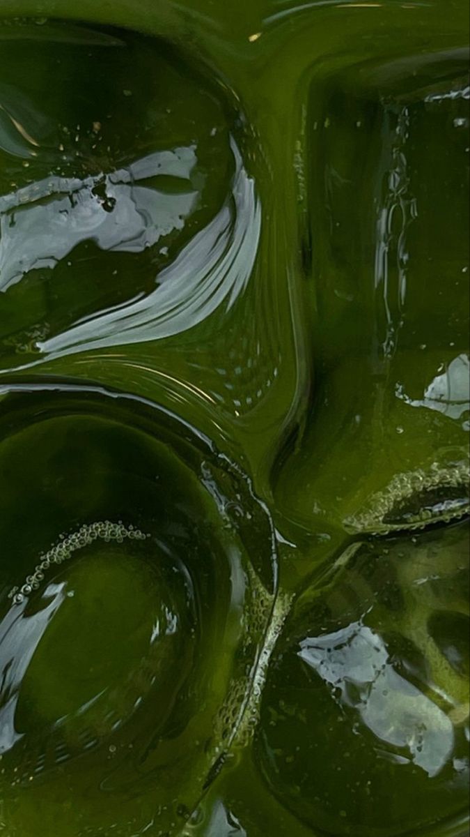 green liquid flowing down the side of a wall in an abstract pattern with white and black dots