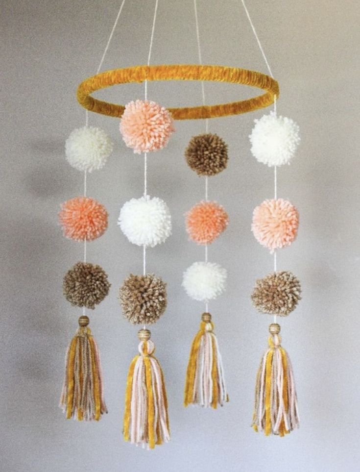 a mobile with pom poms hanging from it