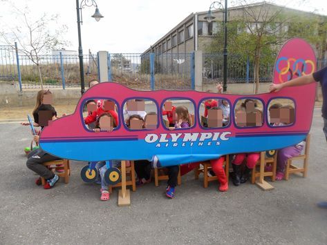 children are sitting in a toy boat with the olympic logo on it