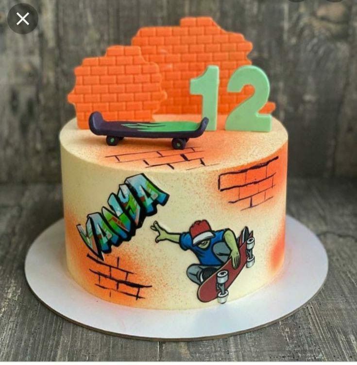 a birthday cake decorated with graffiti and a skateboarder on the top is displayed