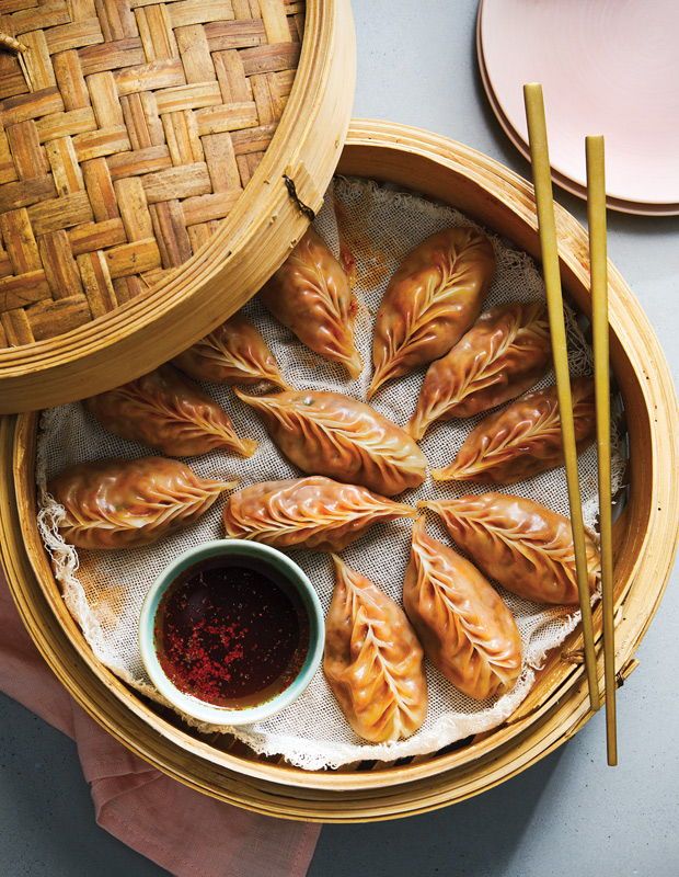 some food is in a basket with chopsticks on the table next to it